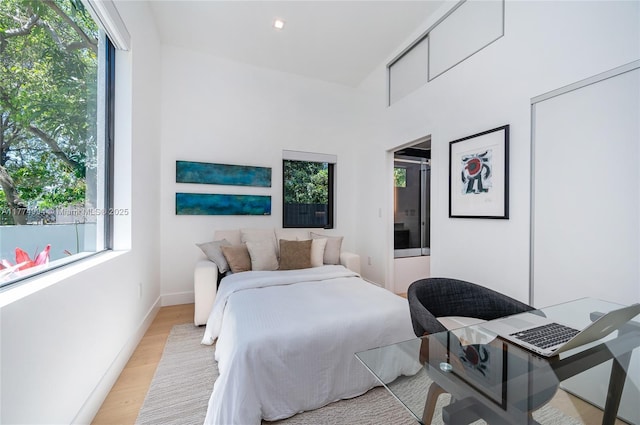bedroom featuring light wood-style flooring, multiple windows, and baseboards