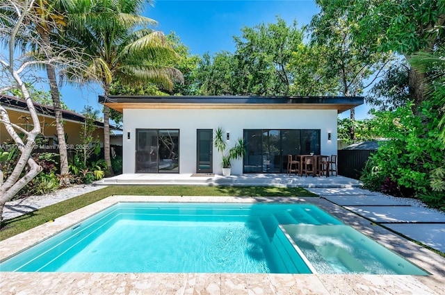 view of swimming pool with a patio area, an outdoor structure, and a pool with connected hot tub