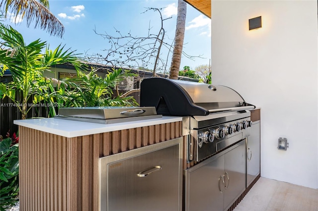 view of patio with exterior kitchen and a grill