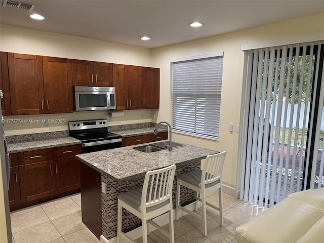 4849 NW 57th Ct, Tamarac, FL 33319 - kitchen featuring visible vents, light tile patterned floors, a sink, a breakfast bar, and stainless steel appliances