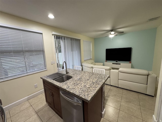 4849 NW 57th Ct, Tamarac, FL 33319 - kitchen with light tile patterned floors, light stone countertops, a ceiling fan, dishwasher, and a sink