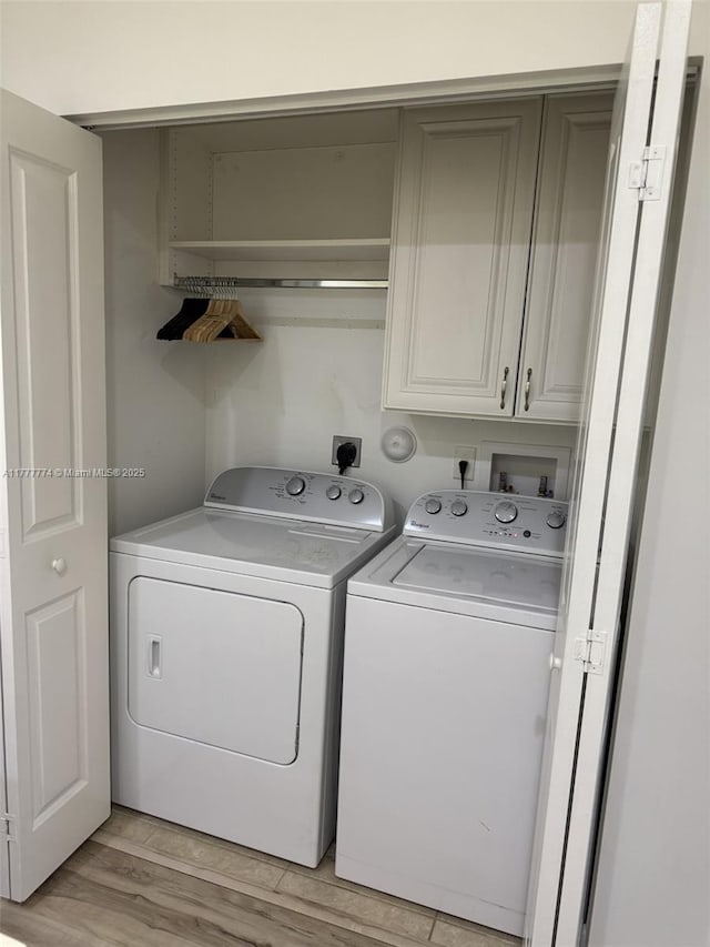 4849 NW 57th Ct, Tamarac, FL 33319 - washroom featuring washer and dryer, light wood-style flooring, and cabinet space