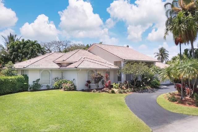 8350 SW 138th Ter, Palmetto Bay, FL 33158 - mediterranean / spanish house with a tiled roof, driveway, stucco siding, and a front lawn