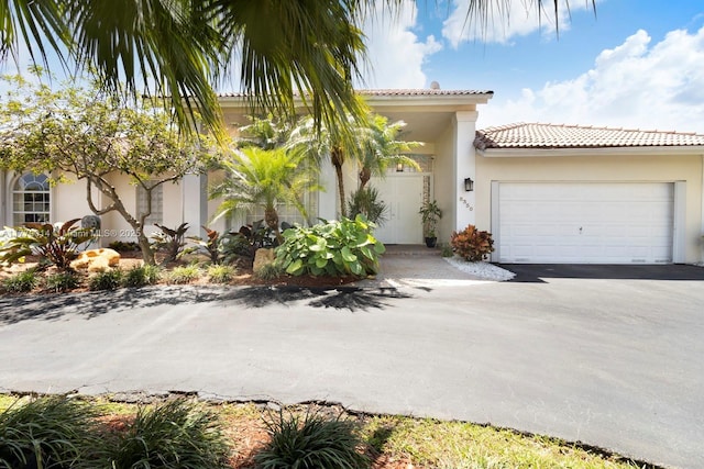 8350 SW 138th Ter, Palmetto Bay, FL 33158 - mediterranean / spanish-style house featuring aphalt driveway, stucco siding, a tile roof, and a garage