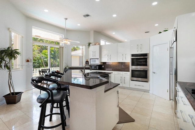 8350 SW 138th Ter, Palmetto Bay, FL 33158 - kitchen featuring tasteful backsplash, white microwave, stainless steel double oven, ceiling fan, and a sink