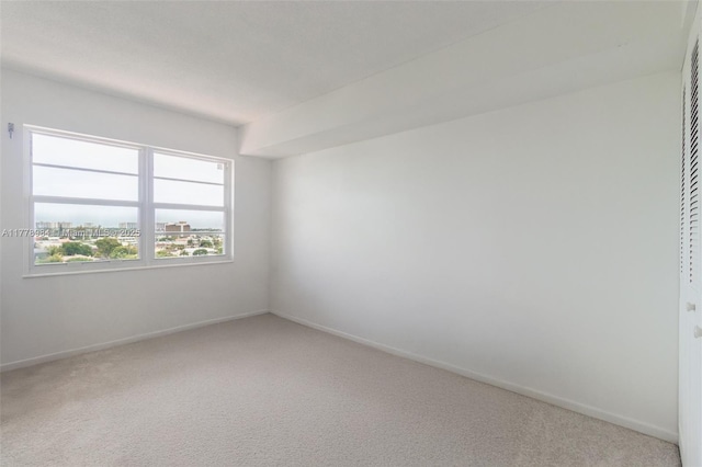 empty room with baseboards and carpet flooring