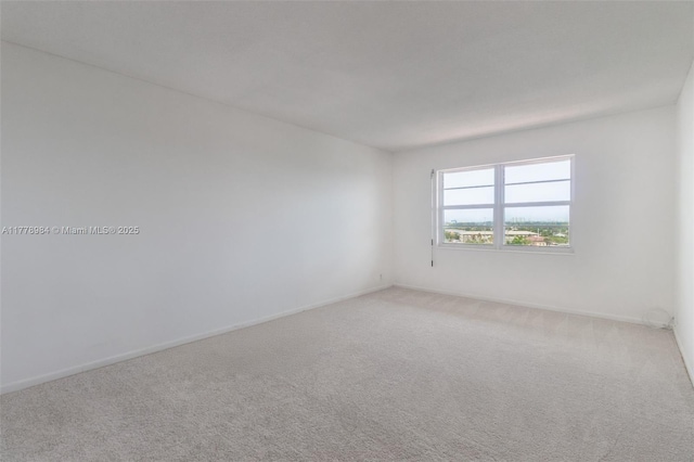 carpeted empty room with baseboards
