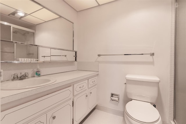 full bath featuring vanity, baseboards, an enclosed shower, and toilet