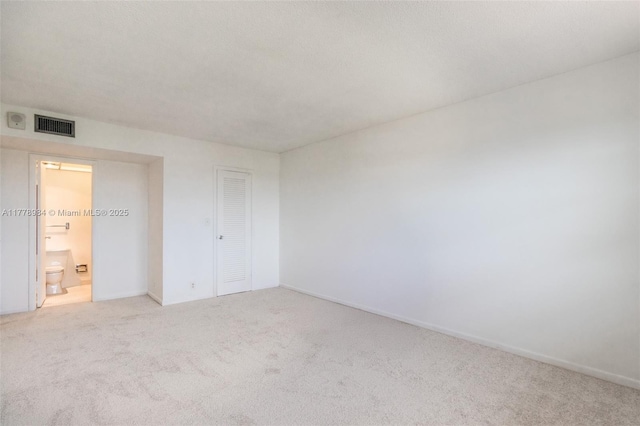 carpeted empty room with baseboards and visible vents