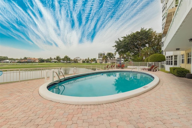 pool with a patio and fence