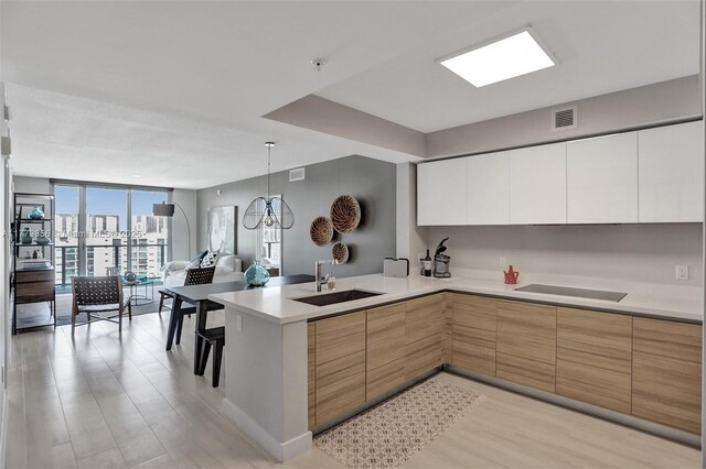 300 Sunny Isles Blvd Unit 4-903, Sunny Isles Beach, FL 33160 - kitchen featuring modern cabinets, a peninsula, open floor plan, black electric cooktop, and light countertops