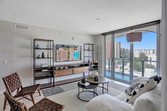 300 Sunny Isles Blvd Unit 4-903, Sunny Isles Beach, FL 33160 - living room featuring a textured ceiling, a wall of windows, and wood finished floors