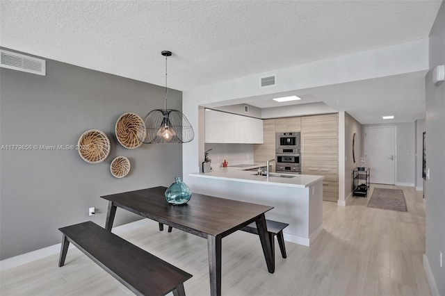 300 Sunny Isles Blvd Unit 4-903, Sunny Isles Beach, FL 33160 - dining area featuring light wood-type flooring and a textured ceiling