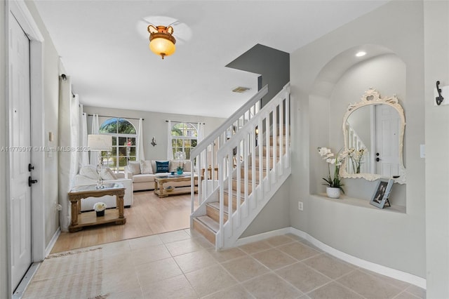 stairway with tile patterned flooring, visible vents, and baseboards