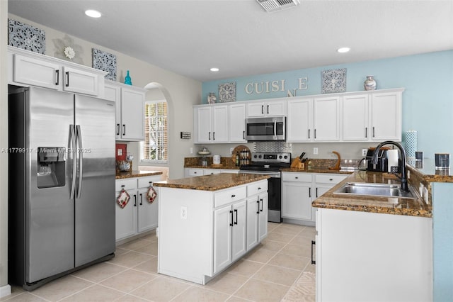 kitchen featuring stainless steel appliances, white cabinetry, a sink, and light tile patterned flooring