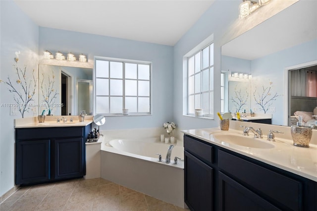 bathroom with tile patterned floors, a bath, a sink, and two vanities