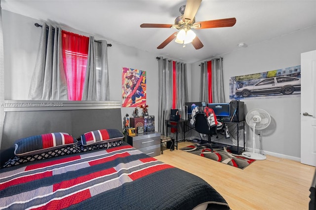 bedroom with baseboards, a ceiling fan, and wood finished floors