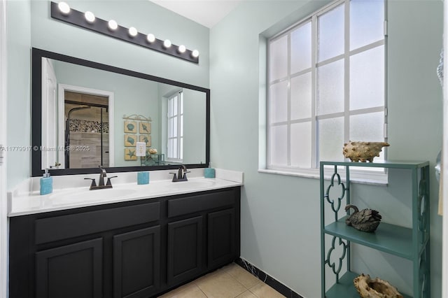 bathroom featuring a shower stall, double vanity, a sink, and tile patterned flooring