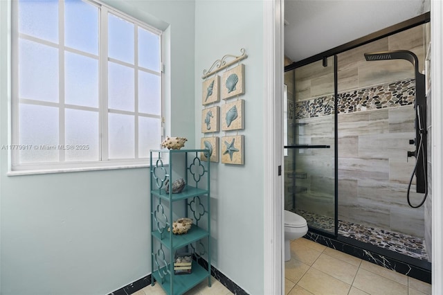 bathroom featuring a shower stall, tile patterned floors, and toilet