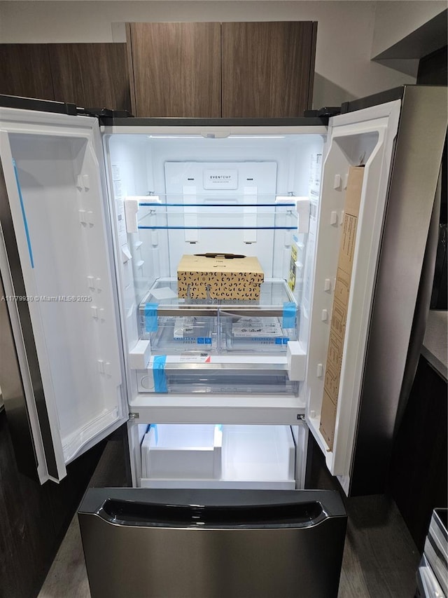 room details with dark brown cabinets and refrigerator