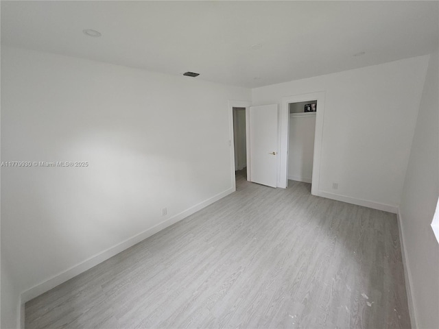 interior space featuring light wood-style floors, baseboards, and visible vents
