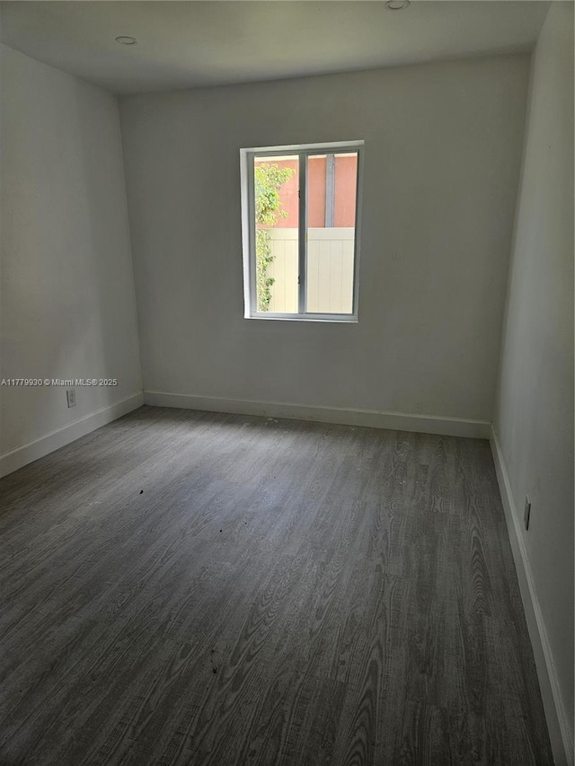 spare room with wood finished floors and baseboards