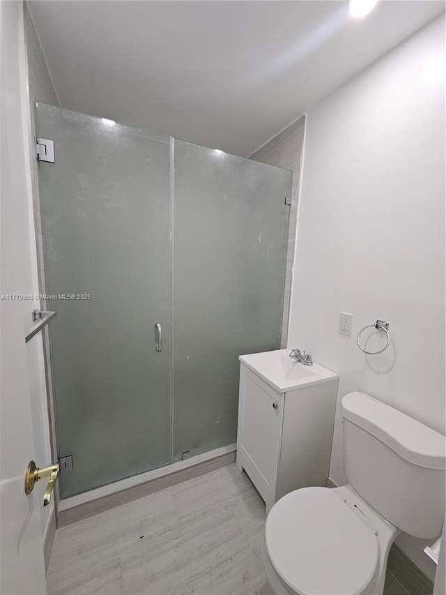 full bath with a shower stall, vanity, and toilet