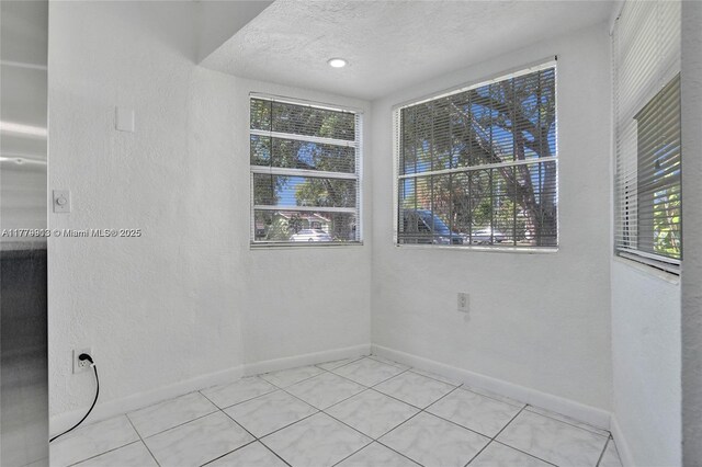 2001 N 26th Ave, Hollywood, FL 33020 - empty room featuring healthy amount of natural light, tile patterned flooring, a textured wall, and a textured ceiling
