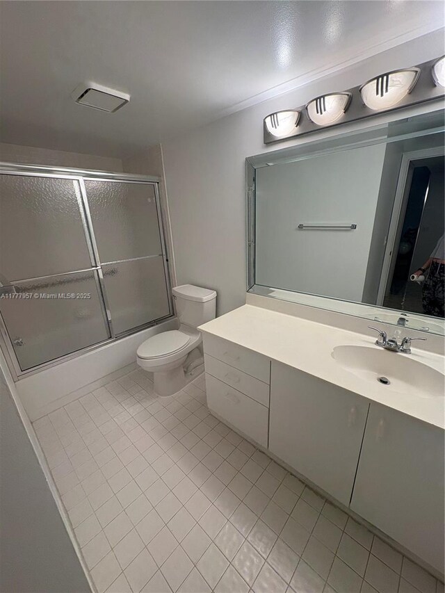 10133 NW 24th Pl Unit 206, Sunrise, FL 33322 - bathroom featuring combined bath / shower with glass door, tile patterned flooring, vanity, and toilet