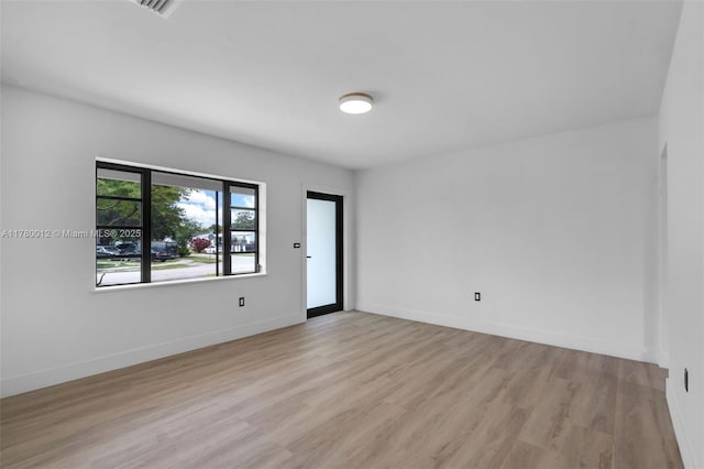 unfurnished room with light wood-style flooring and baseboards