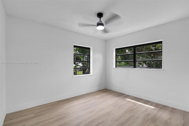 unfurnished room with baseboards, a ceiling fan, and wood finished floors
