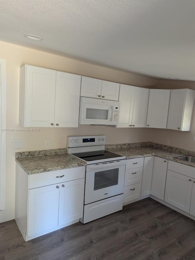 kitchen with dark wood finished floors, white cabinets, and white appliances