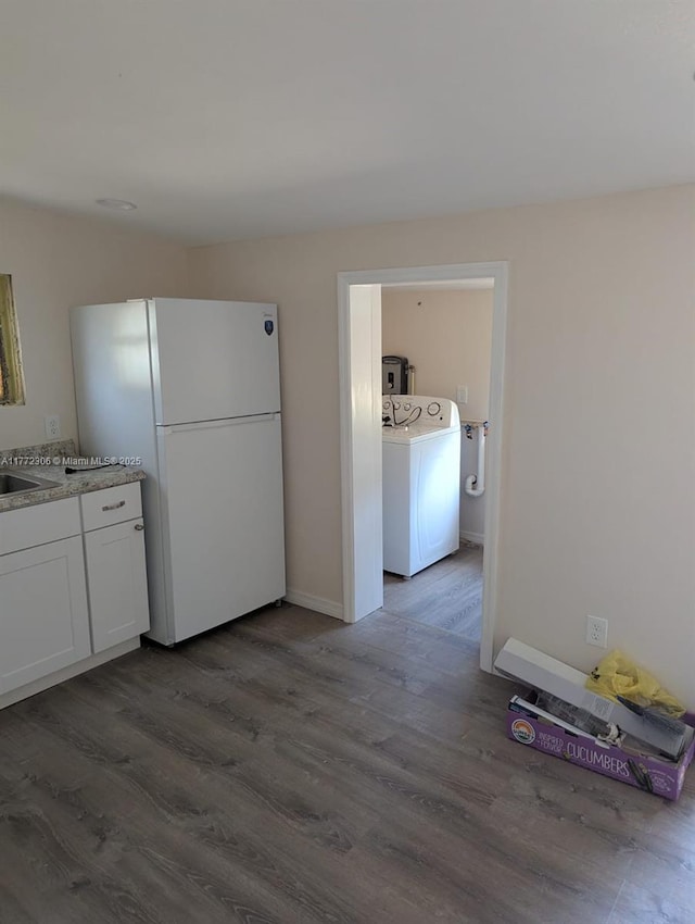 kitchen with a sink, dark wood-style flooring, white cabinets, and freestanding refrigerator