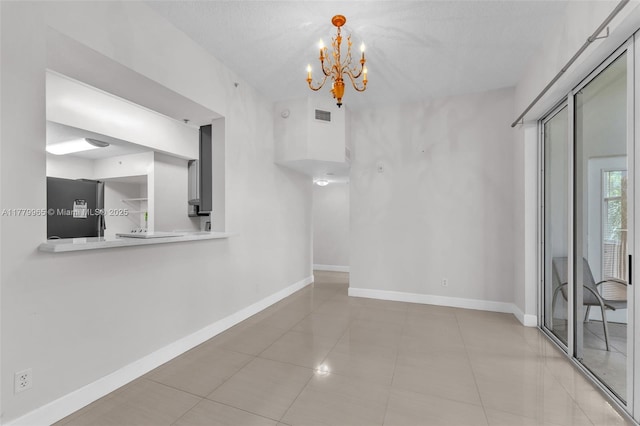 619 E Sheridan St Unit 406, Dania Beach, FL 33004 - unfurnished dining area featuring a chandelier, light tile patterned floors, and baseboards