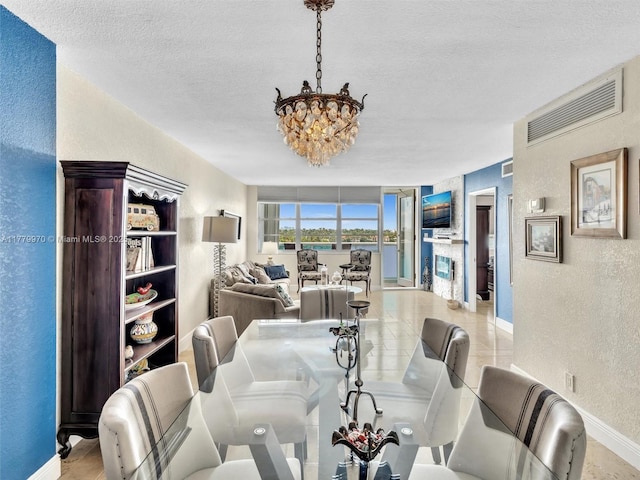 6770 Indian Creek Dr Unit 7K, Miami Beach, FL 33141 - dining area with a textured wall, a chandelier, and a textured ceiling