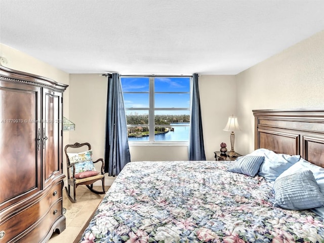6770 Indian Creek Dr Unit 7K, Miami Beach, FL 33141 - bedroom with a textured ceiling, a water view, and light tile patterned floors