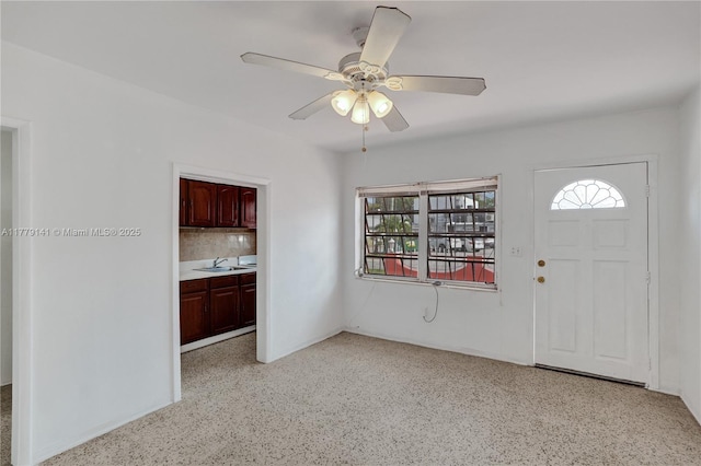 entrance foyer with a ceiling fan, a wealth of natural light, and light speckled floor