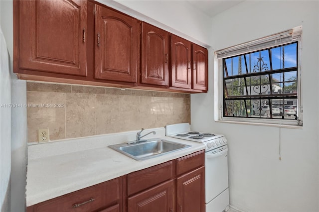 kitchen featuring a sink, white electric stove, tasteful backsplash, and light countertops