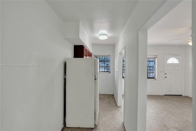 hallway with a wealth of natural light and light speckled floor