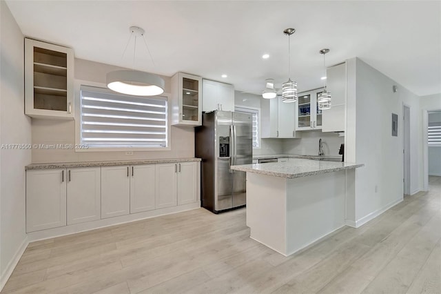 15600 NE 6th Ave Unit 30A, Miami, FL 33162 - kitchen with glass insert cabinets, a peninsula, light wood-style flooring, and stainless steel fridge