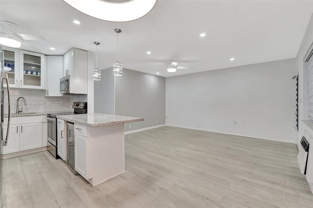 15600 NE 6th Ave Unit 30A, Miami, FL 33162 - kitchen with white cabinetry, a ceiling fan, light stone countertops, stainless steel appliances, and light wood finished floors