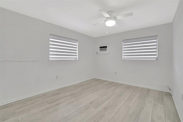 15600 NE 6th Ave Unit 30A, Miami, FL 33162 - empty room featuring a wall unit AC, ceiling fan, baseboards, and wood finished floors