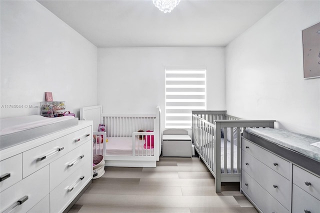 bedroom featuring wood finished floors and a crib