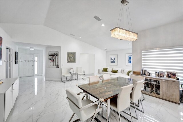dining room with visible vents, marble finish floor, a chandelier, and lofted ceiling