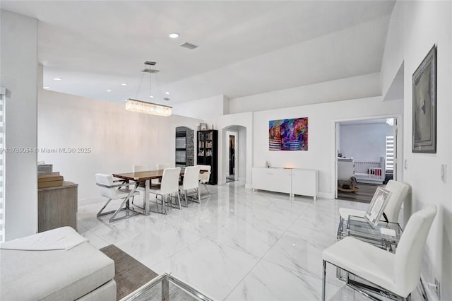living area with baseboards, recessed lighting, visible vents, arched walkways, and marble finish floor