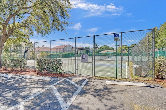 view of sport court with fence, community basketball court, and a gate