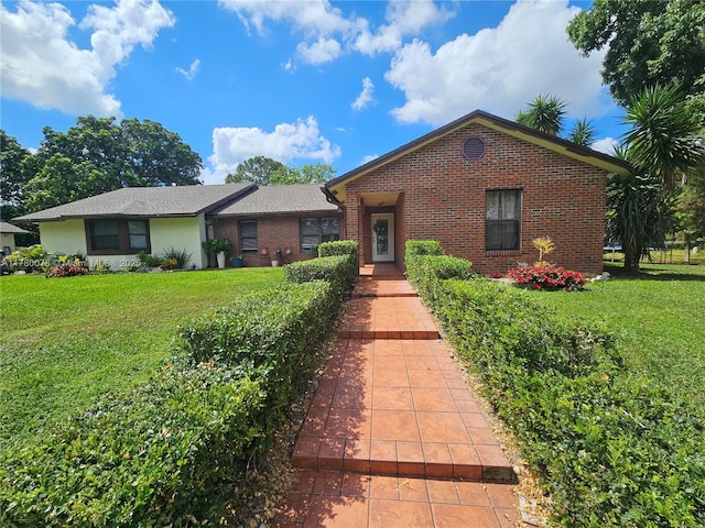 single story home with brick siding and a front yard