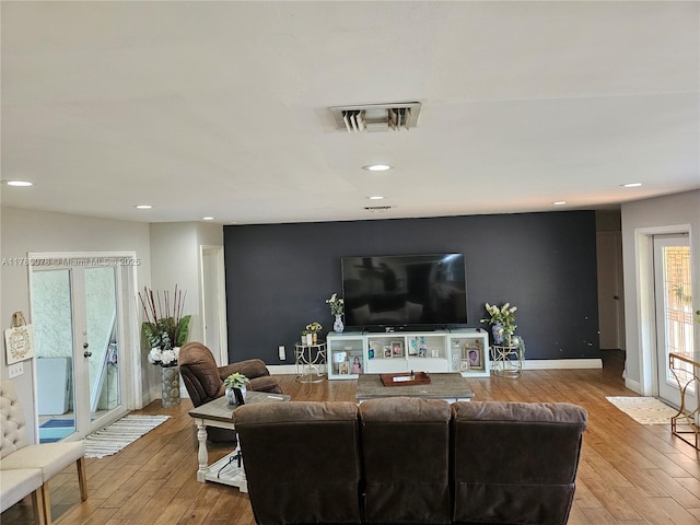 living area featuring wood finished floors, visible vents, recessed lighting, and baseboards