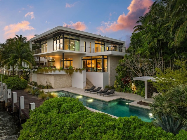 3832 Bayside Ct, Miami, FL 33133 - rear view of property featuring a patio area, an outdoor pool, stucco siding, and a balcony
