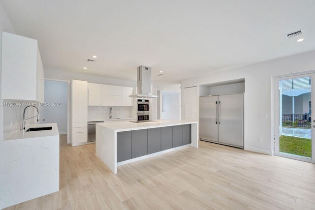 3527 Forest View Cir, Dania Beach, FL 33312 - kitchen with modern cabinets, island exhaust hood, stainless steel appliances, and a sink